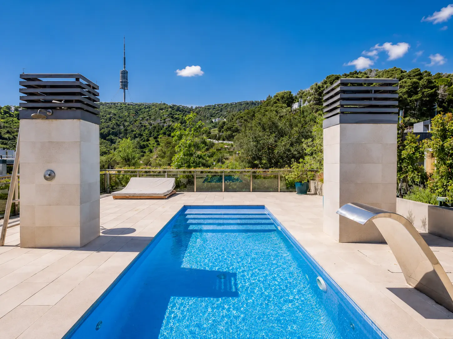 Long lap pool on a terrace with panoramic city and mountain views